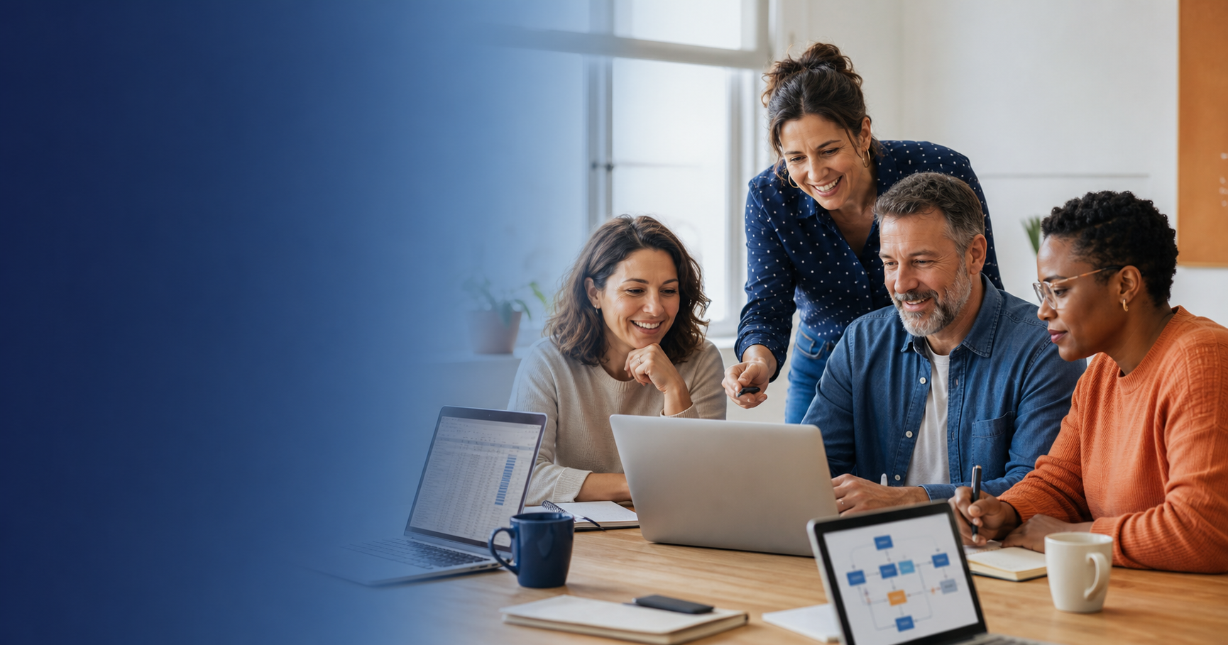 Des adultes apprennent ensemble à utiliser des outils numériques, accompagnés par une formatrice.